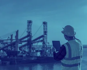 A worker at a Maritime port pointing at port site
